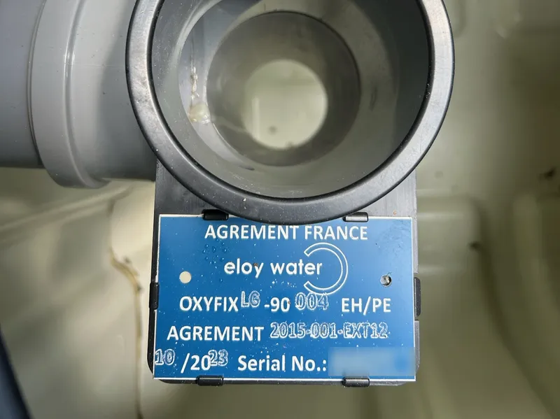La plaque d’agrément Eloy Water Oxyfix fixée dans la cuve d’une micro-station.