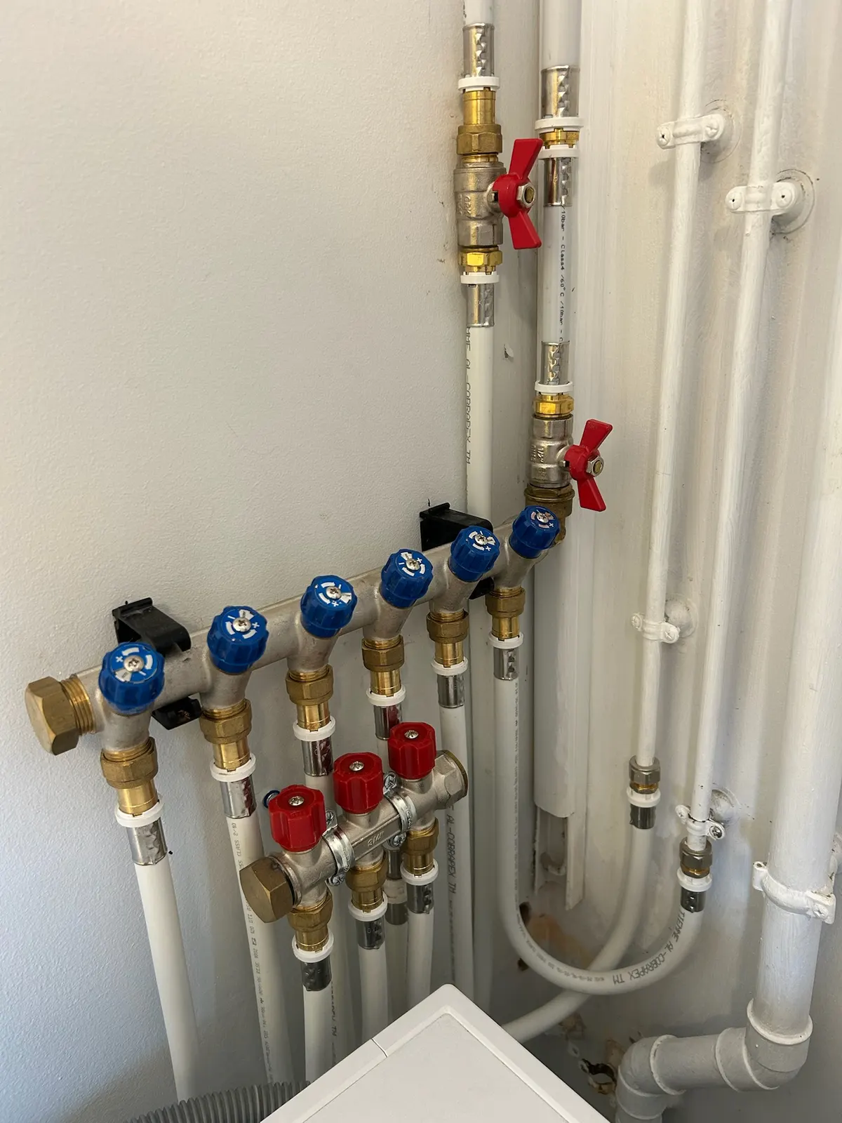 Les vannes de la nourrice de distribution au mur, chaque circuit repéré.