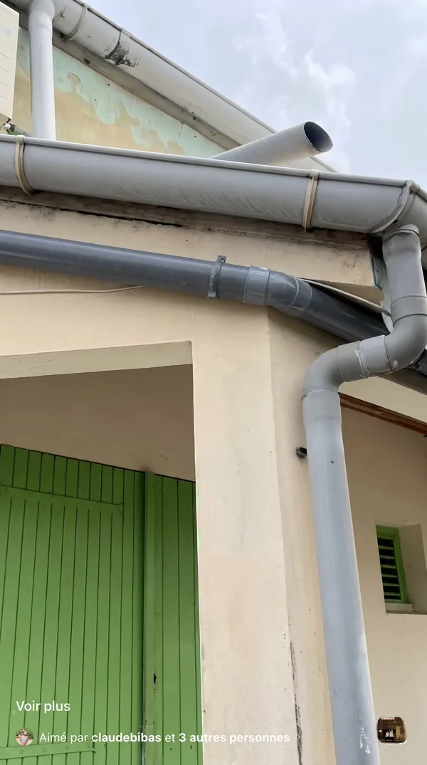 Installation de tuyaux de ventilation en PVC gris sur la façade extérieure d'une maison.