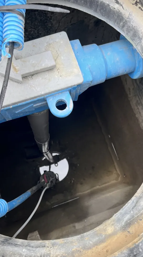 Intérieur d'une cuve de récupération d'eau de pluie avec système de pompage.
