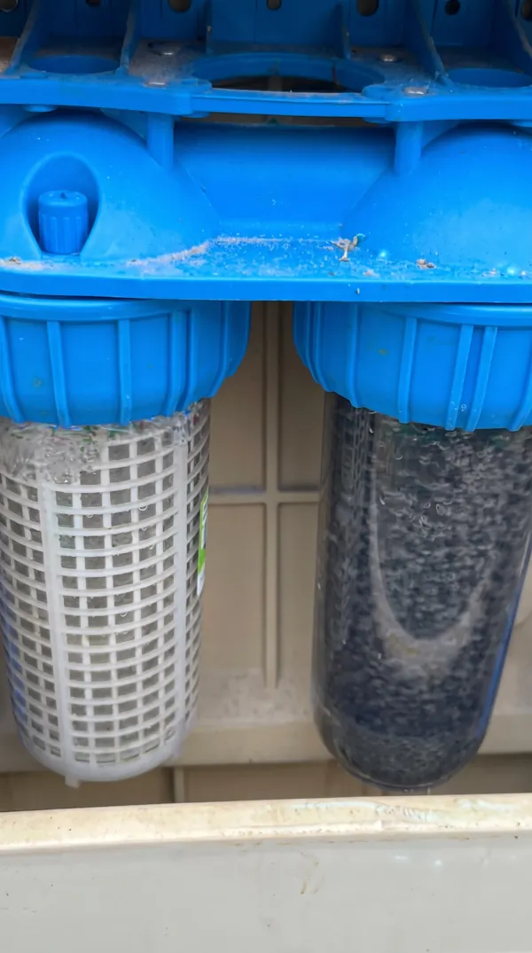 Double filtre à eau domestique bleu après nettoyage et maintenance.